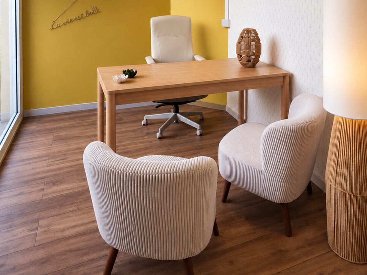 Salle Soleil à Lésigny : bureau en bois, murs ocre et deux fauteuils clairs pour recevoir en consultation